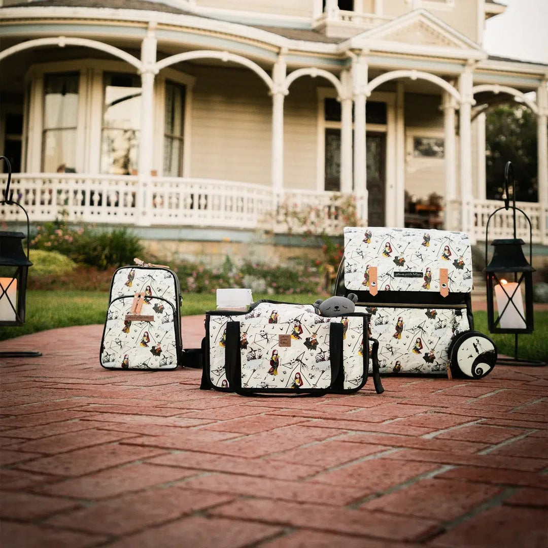 Three bags featuring a Nightmare Before Christmas Print, on the ground in front of a Victorian Home