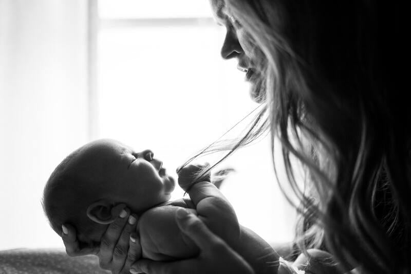 Mother hold and looking at newborn child - black and white