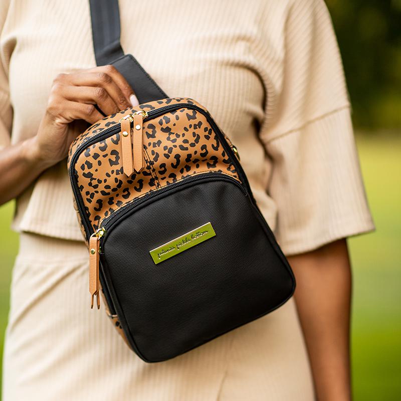mom wearing criss cross sling crossbody style featured in leopard and black