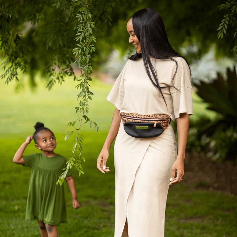 mom wearing leopard belt bag fanny pack walking with daughter