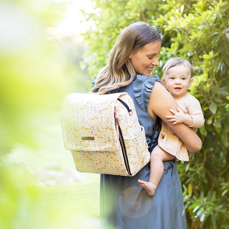 mom wearing boxy backpack shown in whimsical belle carrying toddler