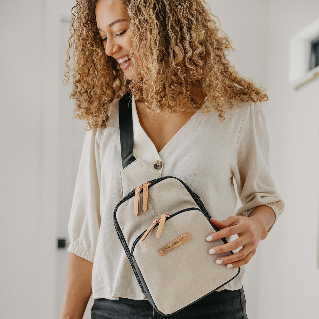 mom wearing the criss-cross sling in black/sand