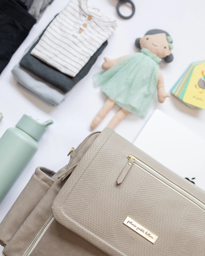 boxy backpack deluxe flat lay in sand leatherette showing multiple baby necessities that all fit inside this large capacity bag