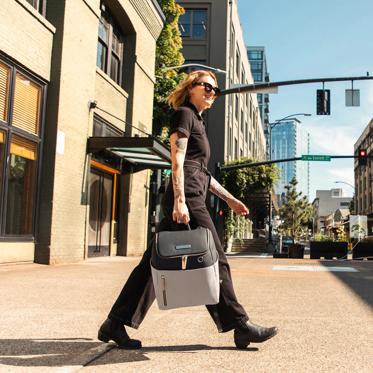 mom walking while holding the tempo backpack in black/sand