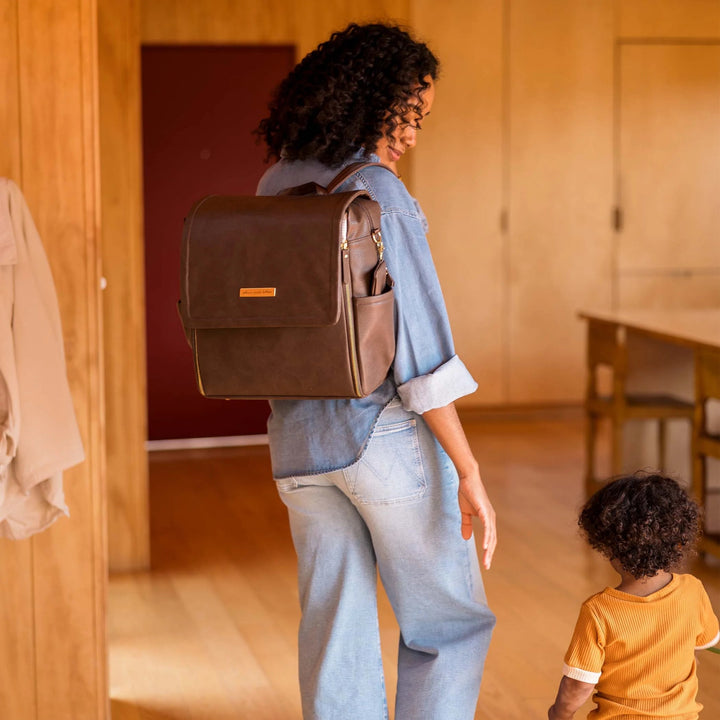 mom with baby while wearing the Boxy Backpack in Saddle