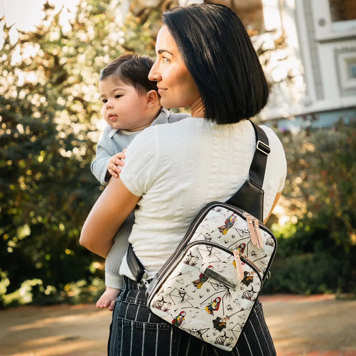 mom holding baby and wearing the criss-cross sling in halloween town