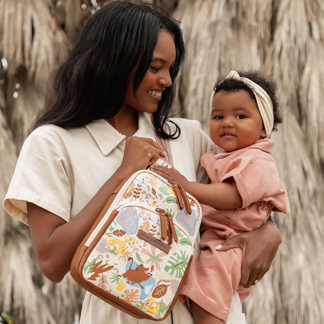 mom holding baby while wearing the Criss-Cross Sling in Hakuna Matata