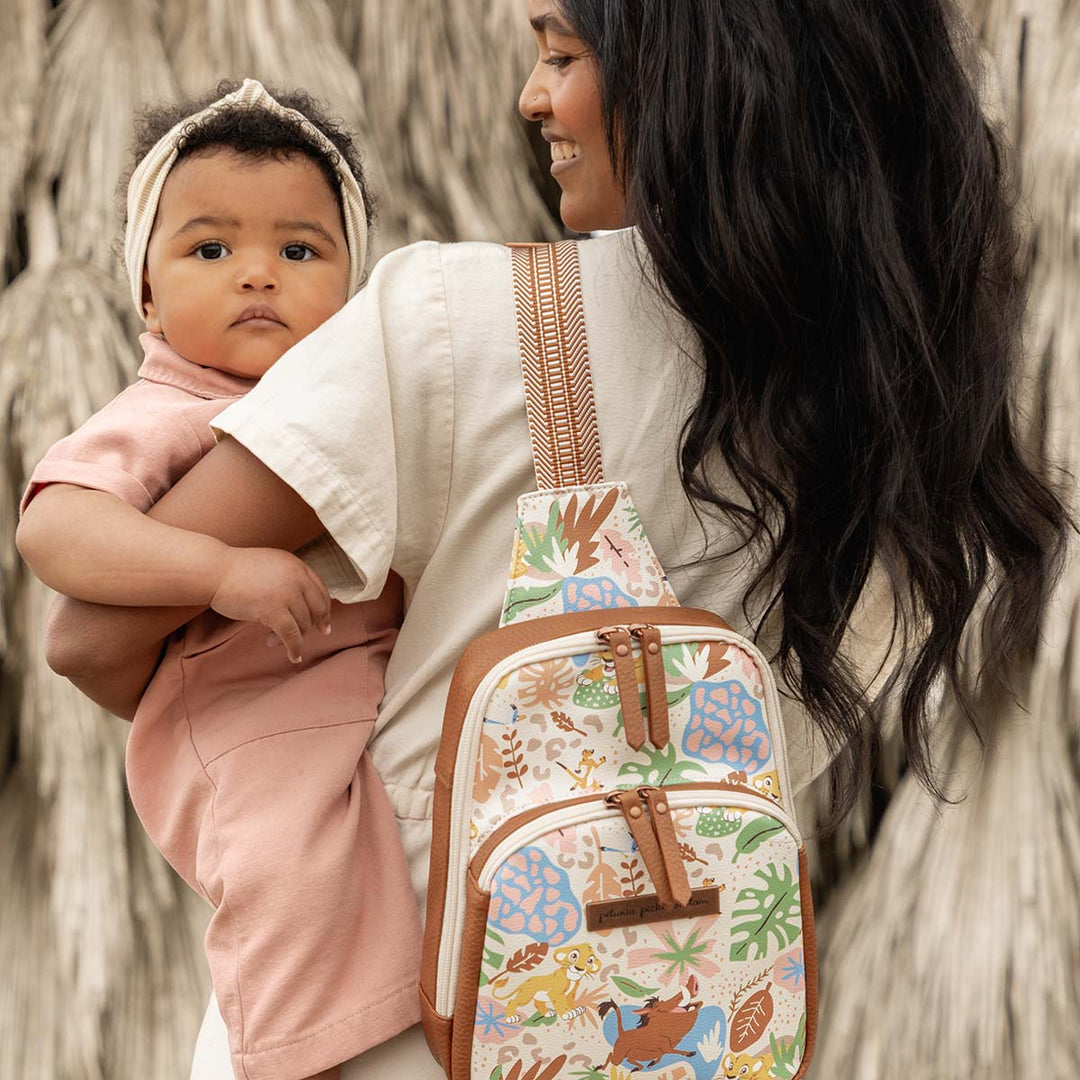 mom holding baby while wearing the Criss-Cross Sling in Hakuna Matata