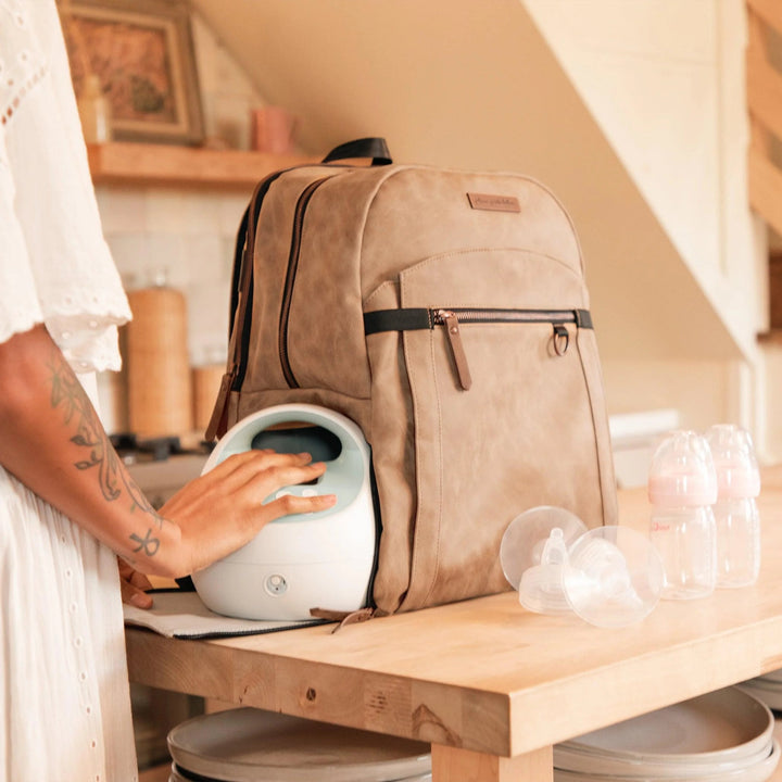 mom putting in breast pump in the provisions backpack in brioche