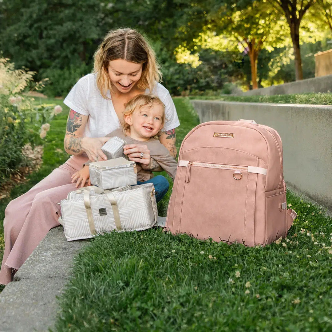 mom with baby and provisions backpack in toffee rose with inter-mix deluxe kit in checker stitch which is sold separately.
