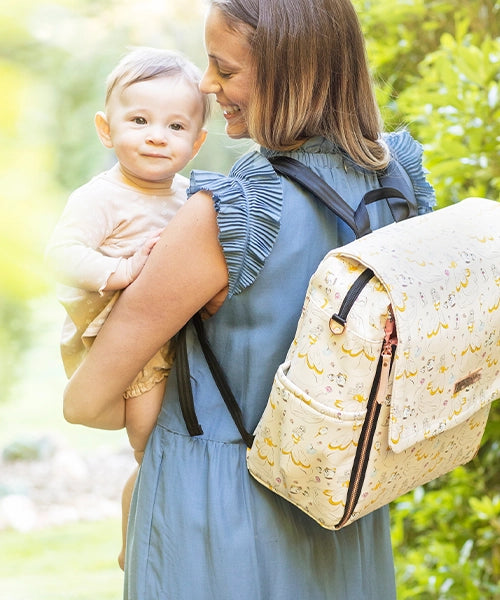 mom carrying baby while wearing the boxy backpack in whimsical belle