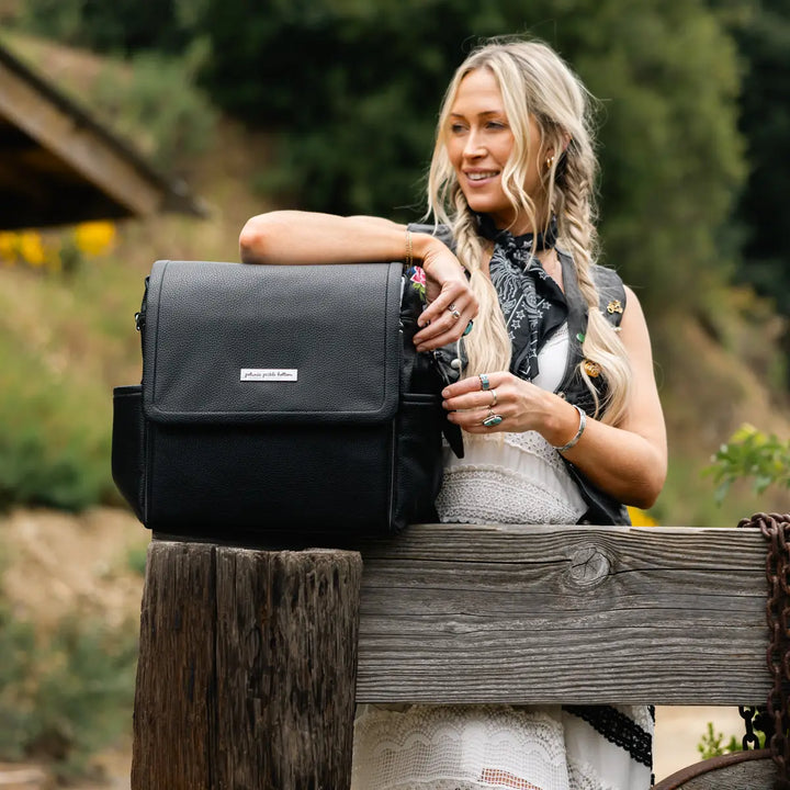 mom putting her elbow on the boxy backpack in ebony