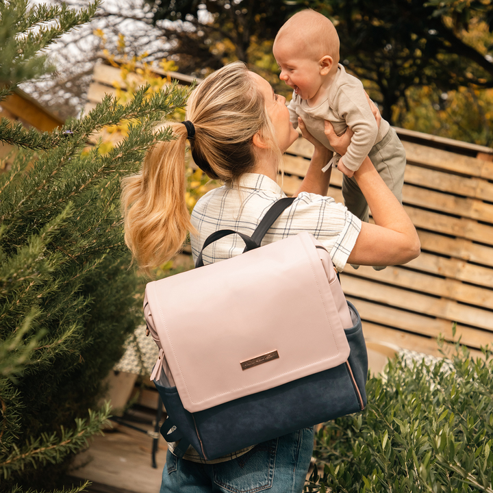 mom carrying baby while wearing the boxy backpack in indigo blush