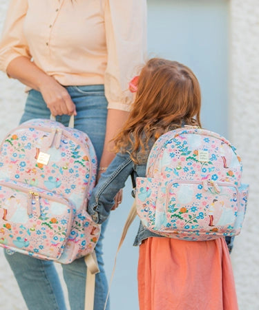 little girl wearing the mini district backpack in cinderella while mom is holding the district backpack in cinderella
