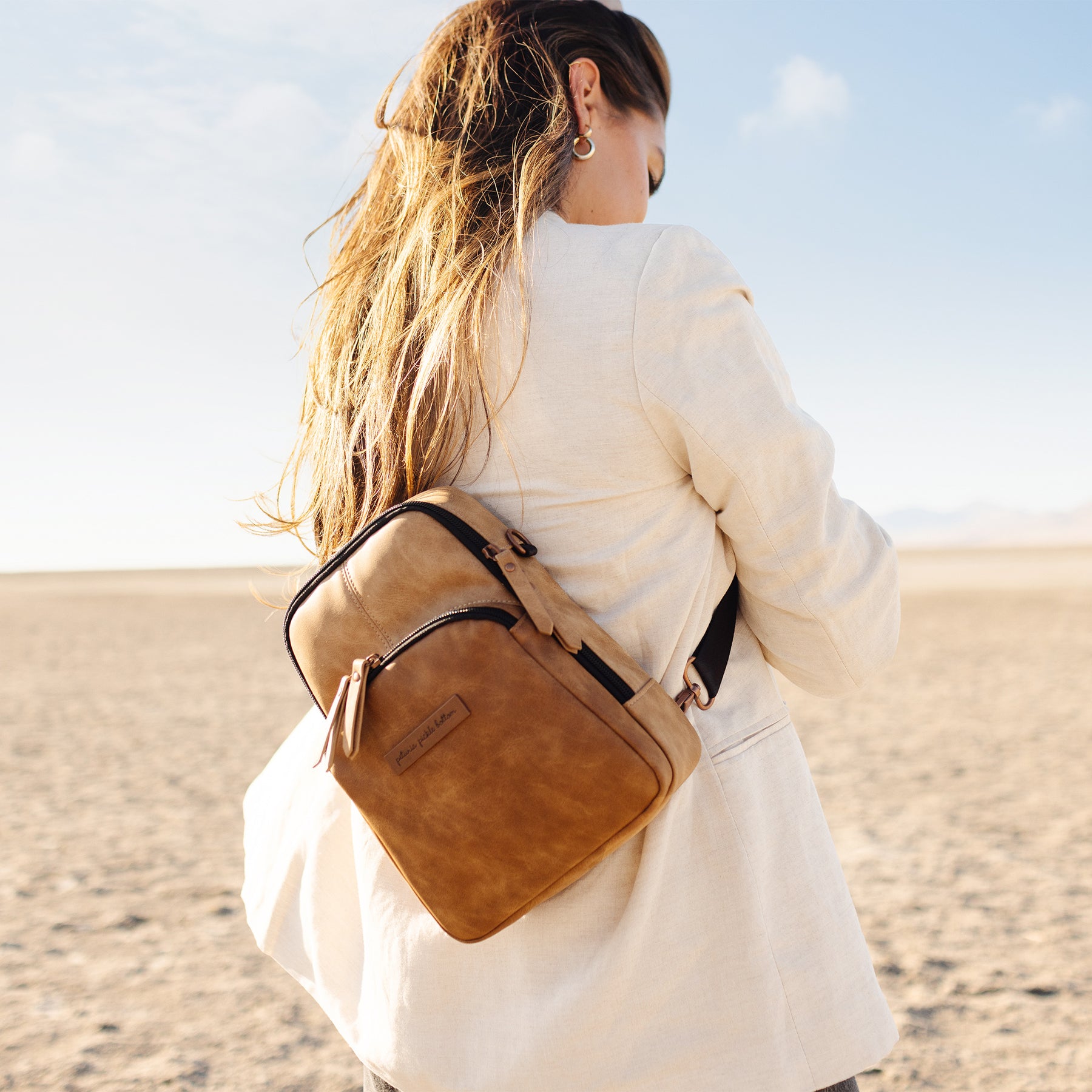 mom wearing criss-cross sling mini backpack in brioche color