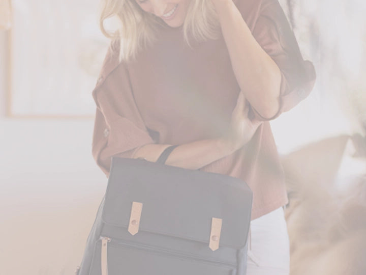 mom holding the meta backpack in black matte leatherette