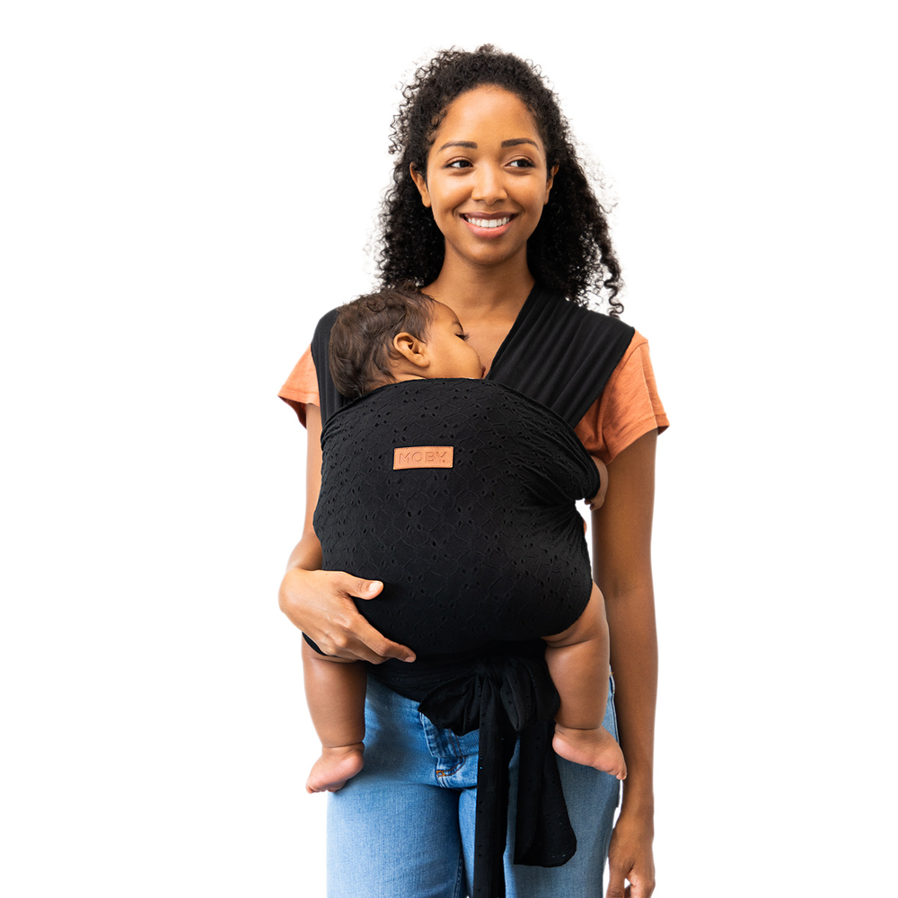 mom wearing baby in Petunia Pickle Bottom x MOBY Easy Wrap Carrier in Black Eyelet