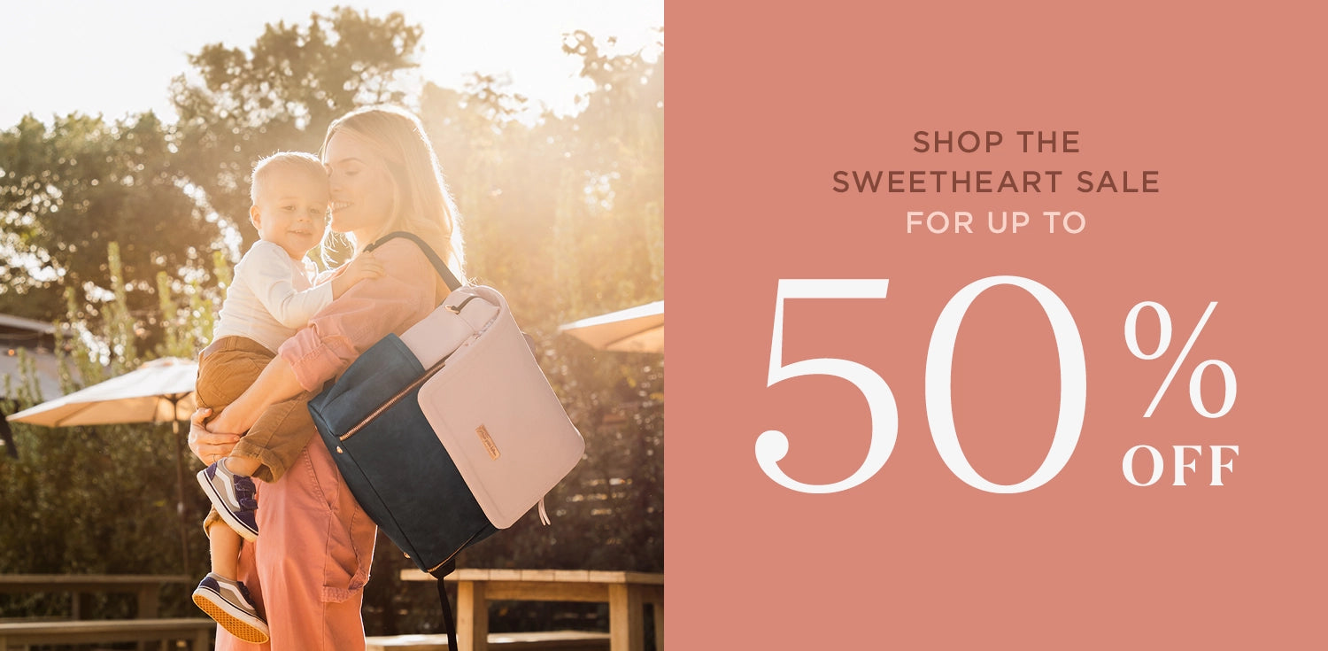 shop the sweetheart sale for up to 50% off. mom wearing diaper bag backpack while holding baby