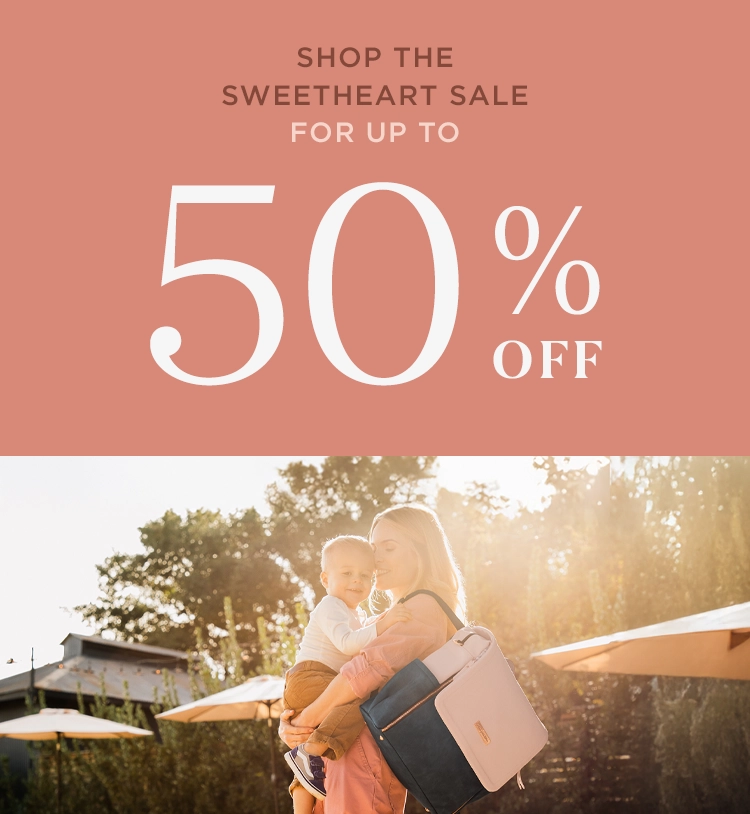 shop the sweetheart sale for up to 50% off. mom wearing diaper bag backpack while holding baby