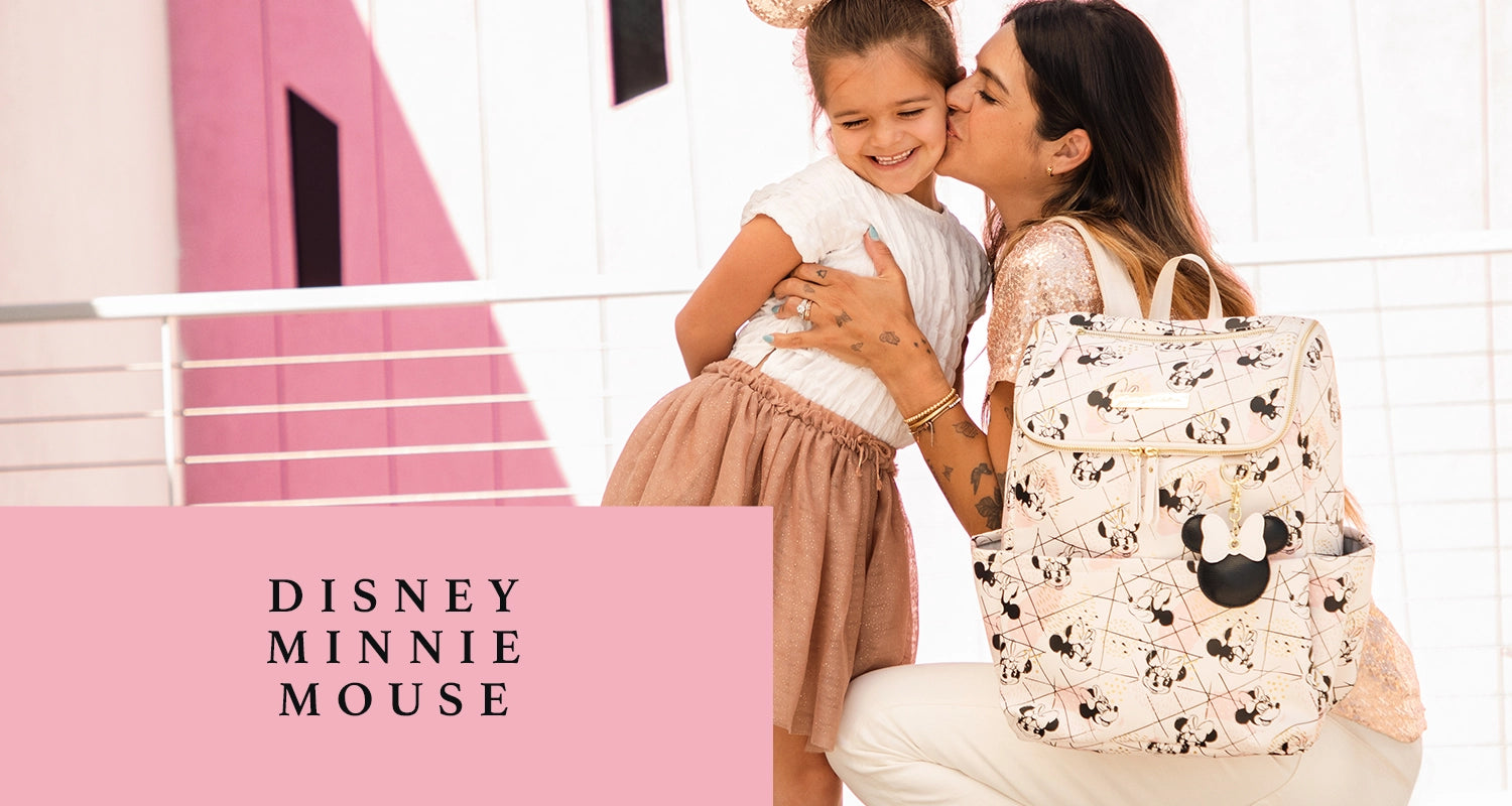 disney minnie mouse. mom kissing girl on the cheek while wearing the method backpack in shimmery minnie mouse