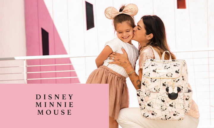 disney minnie mouse. mom kissing girl on the cheek while wearing the method backpack in shimmery minnie mouse