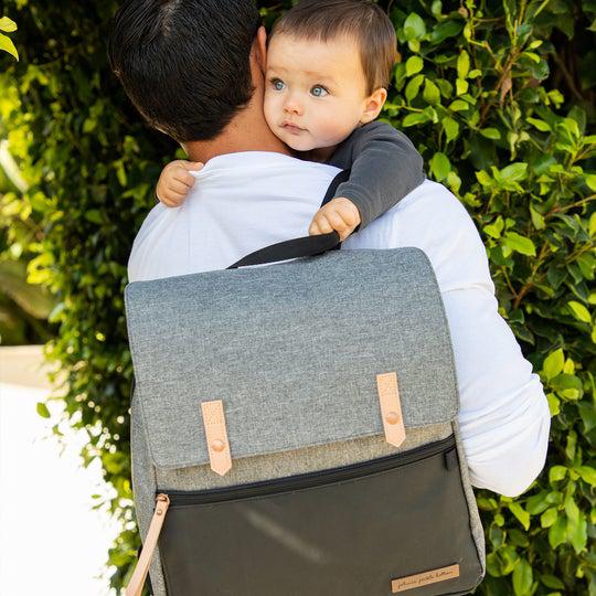Dad in black boxy backpack holding baby son