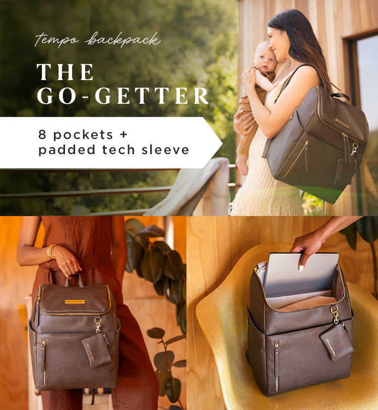 tempo backpack. the go-getter. 8 pockets + padded tech sleeve. mom holding baby while wearing the tempo backpack in saddle.