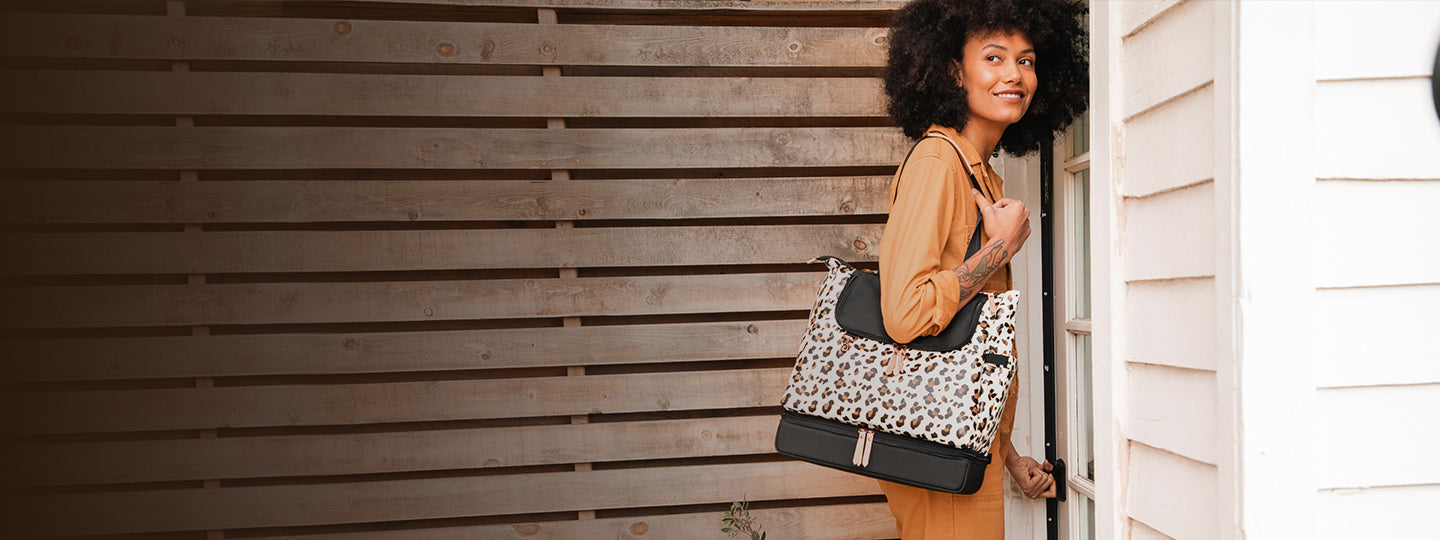 mom wearing tote style diaper back in leopard print pattern