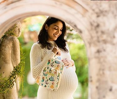 pregnant mom in white dress wearing the criss-cross sling in disney princess courage and kindness