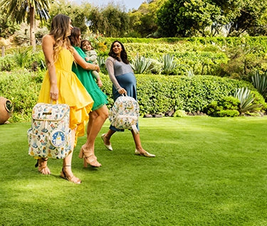 3 moms walking while holding the method and district backpack in disney princess courage and kindness