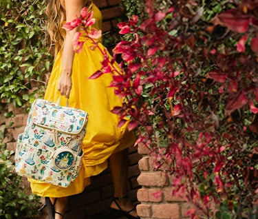 mom with yellow dress holding the method backpack in disney princess courage and kindness