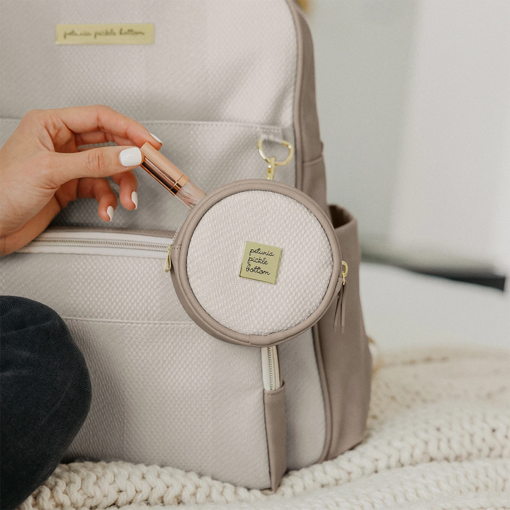 mom putting in lip gloss inside the petite porter in grey matte cable stitch