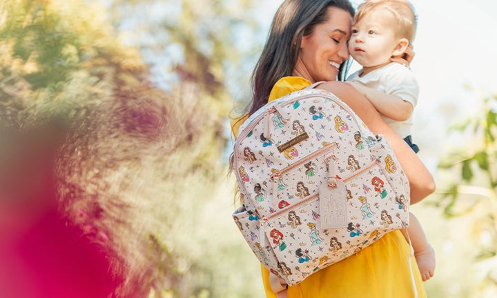 mom holding and hugging baby while wearing the ace backpack in disney princess