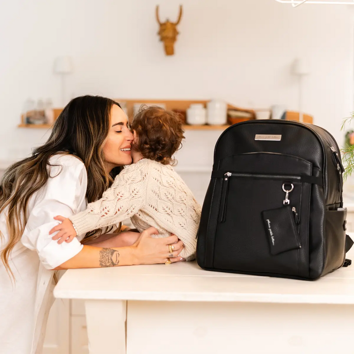 mom wearing the provisions backpack in ebony