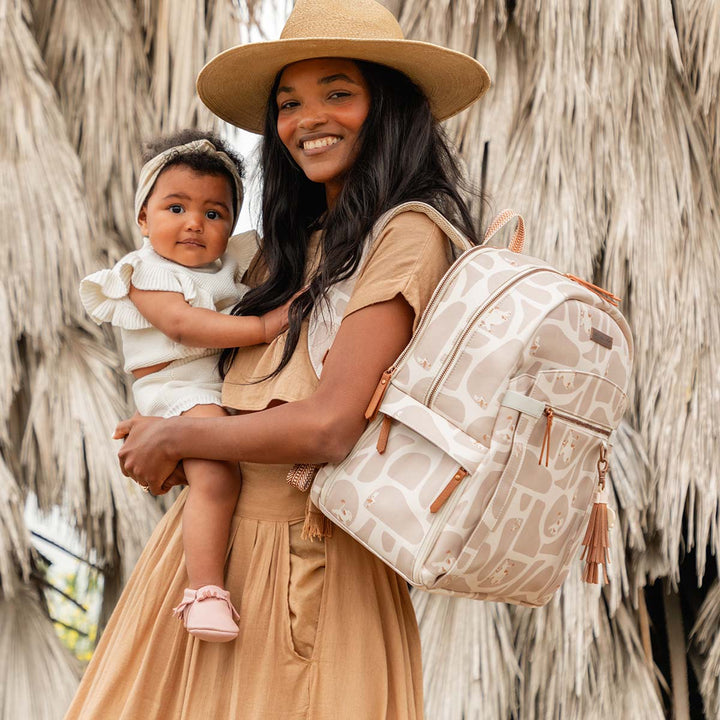 mom holding baby with 2-in-1 Provisions Breast Pump & Diaper Bag Backpack in Pride Lands on her shoulders