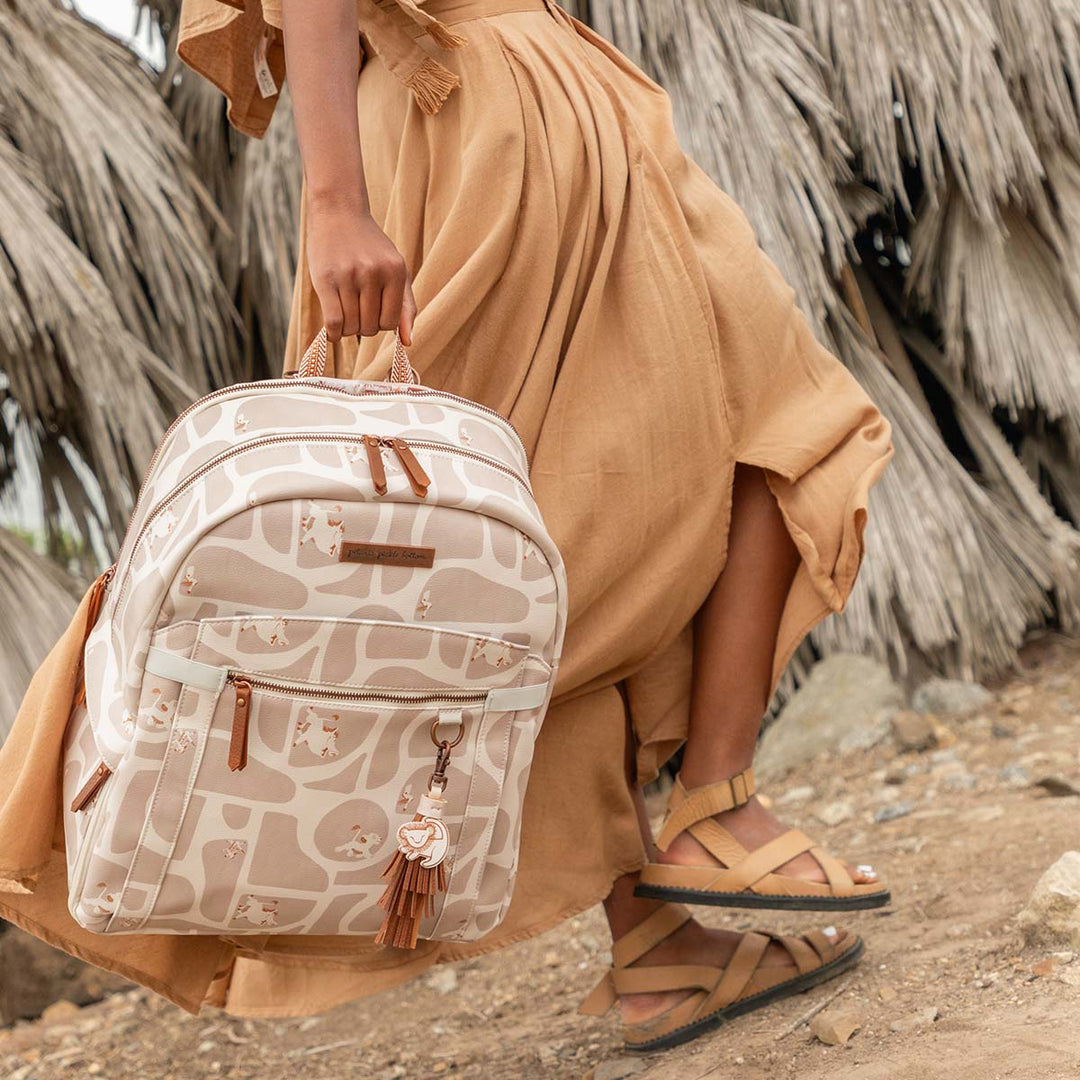 mom walking while holding the 2-in-1 Provisions Breast Pump & Diaper Bag Backpack in Pride Lands