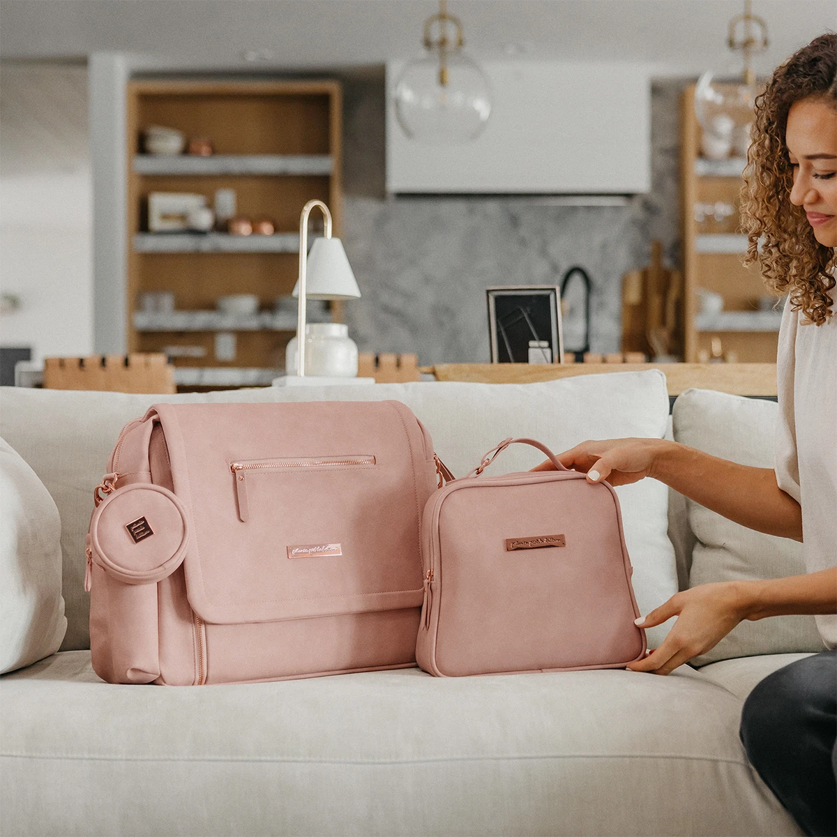 mom placing the tandem lunch tote in toffee rose next to the boxy backpack deluxe in toffee rose