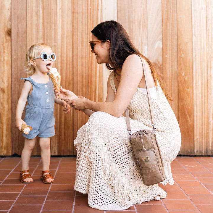 mom feeding ice cream to baby while wearing the Viva Cross-Body in Mink