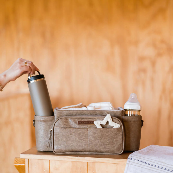 Wander Stroller Caddy Deluxe in Mink with a water bottle being put inside