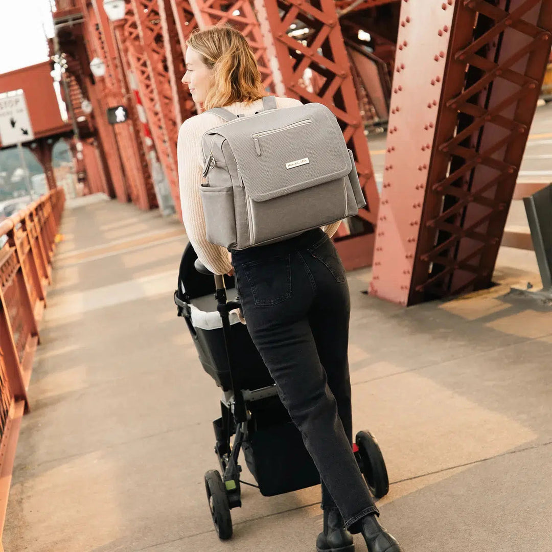 Boxy Backpack Deluxe shown on mom pushing stroller in urban environment