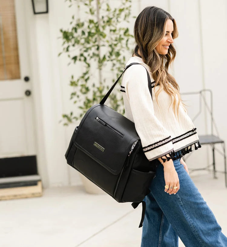 mom holding baby while wearing the boxy backpack deluxe in ebony