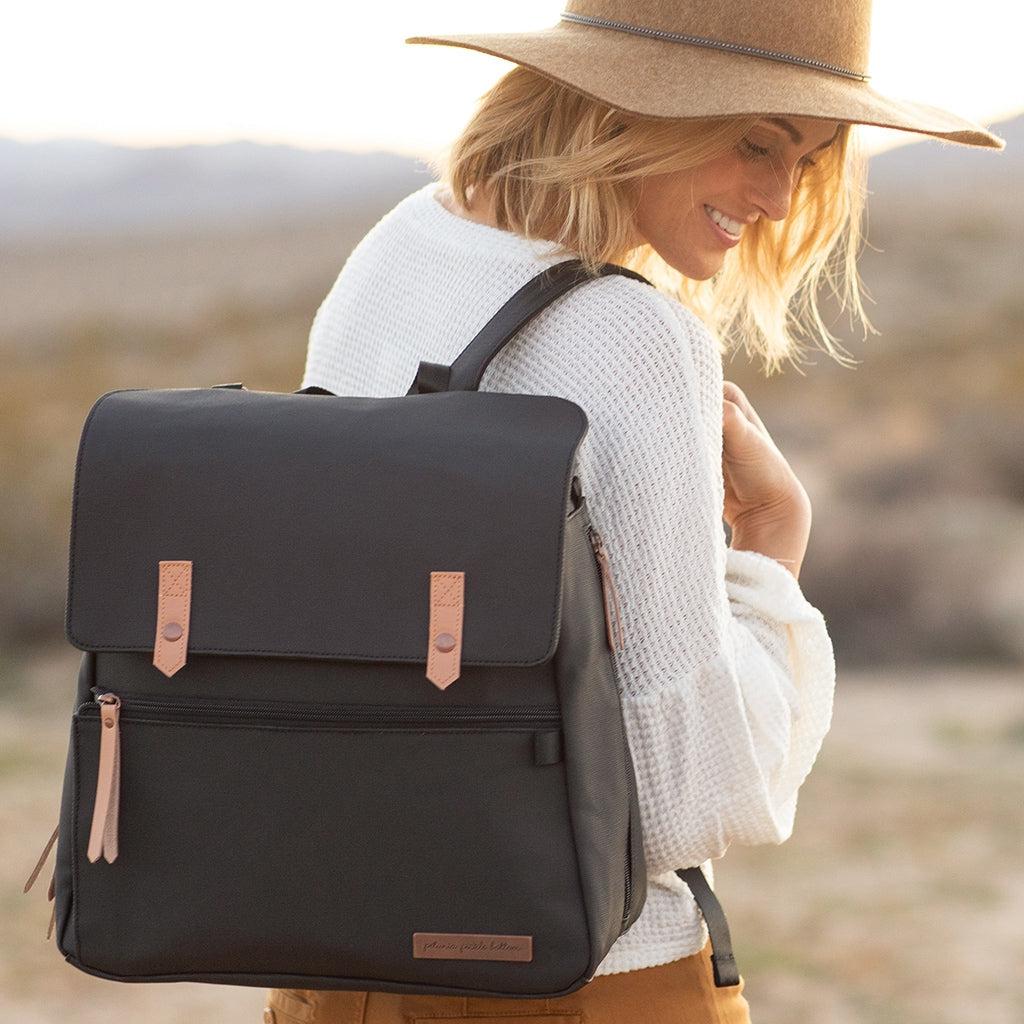 mom wearing the meta backpack in black matte canvas