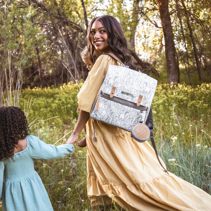 mom holding hand with girl while wearing the meta backpack in playful pooh