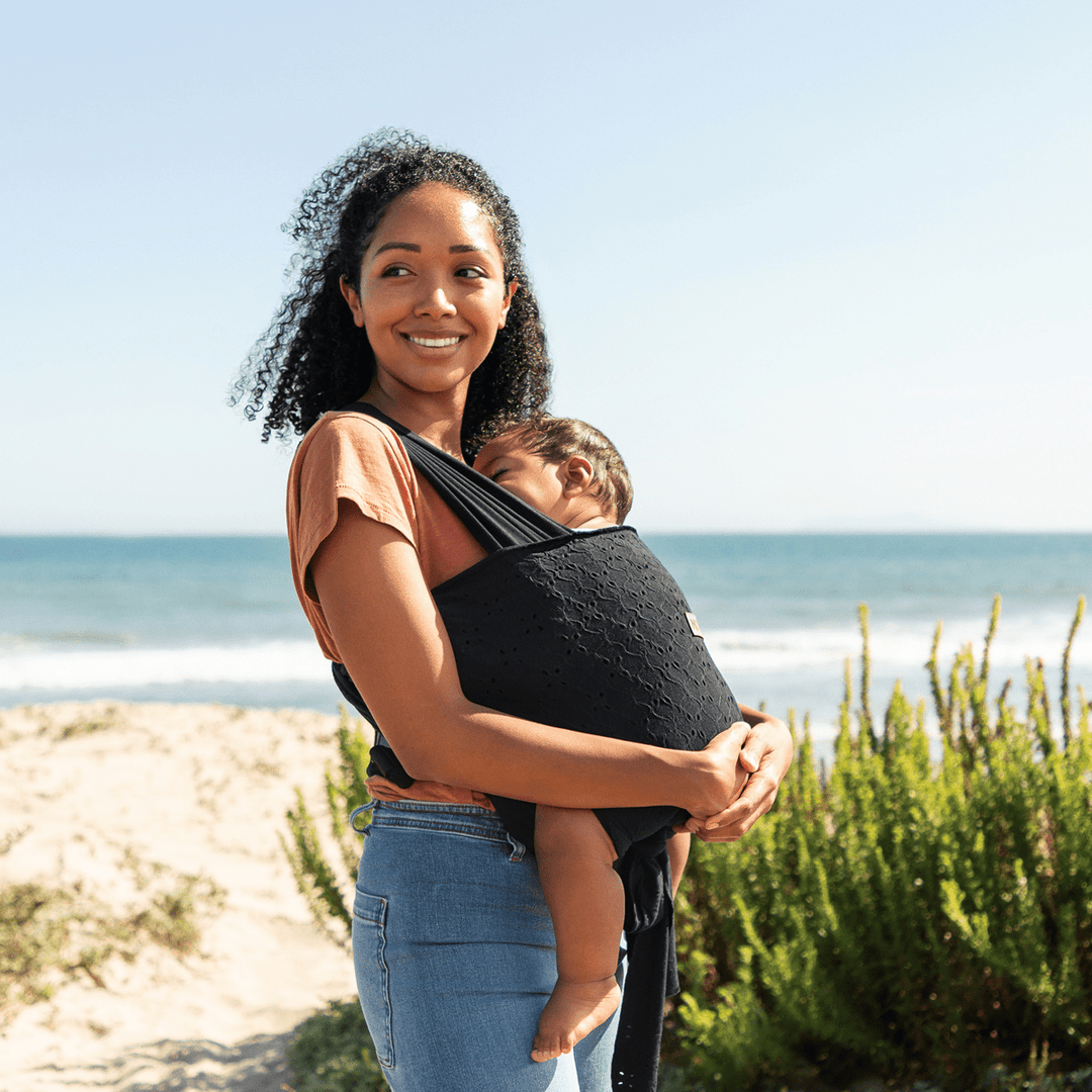 mom wearing baby in Petunia Pickle Bottom x MOBY Easy Wrap Carrier in Black Eyelet