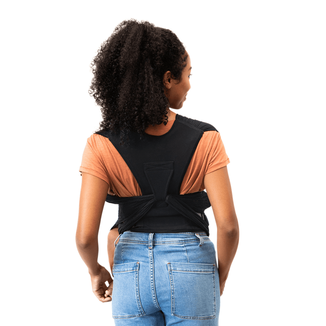 back image of mom wearing baby in petunia x moby easy wrap in black eyelet