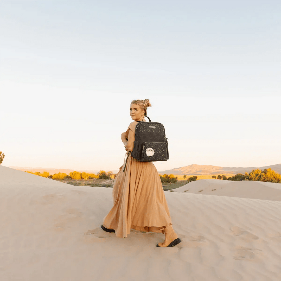 mom wearing the Sync Backpack in The Child in the desert sand