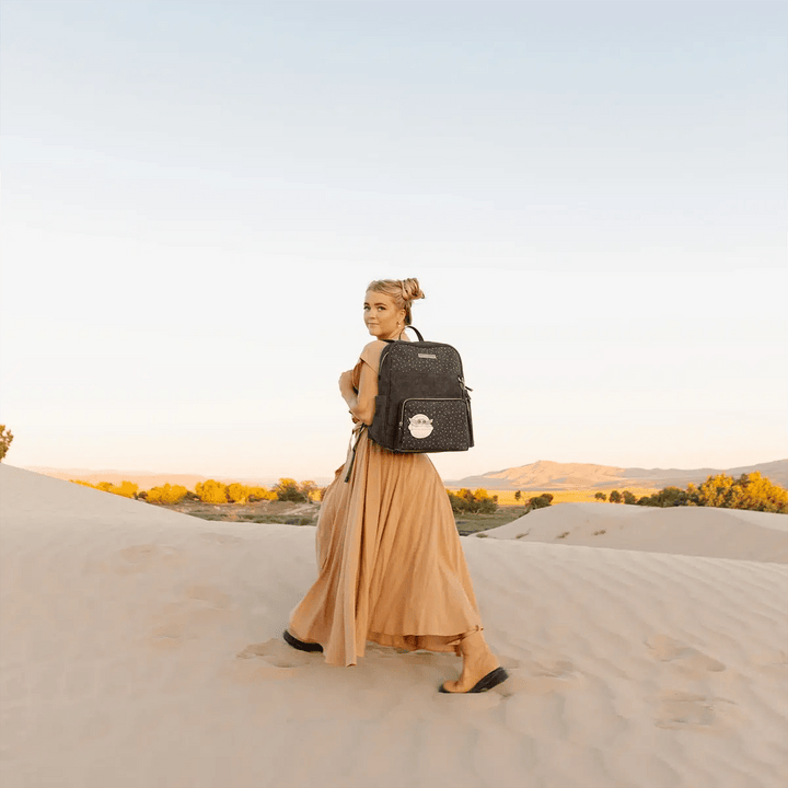 mom wearing the Sync Backpack in The Child in the desert sand