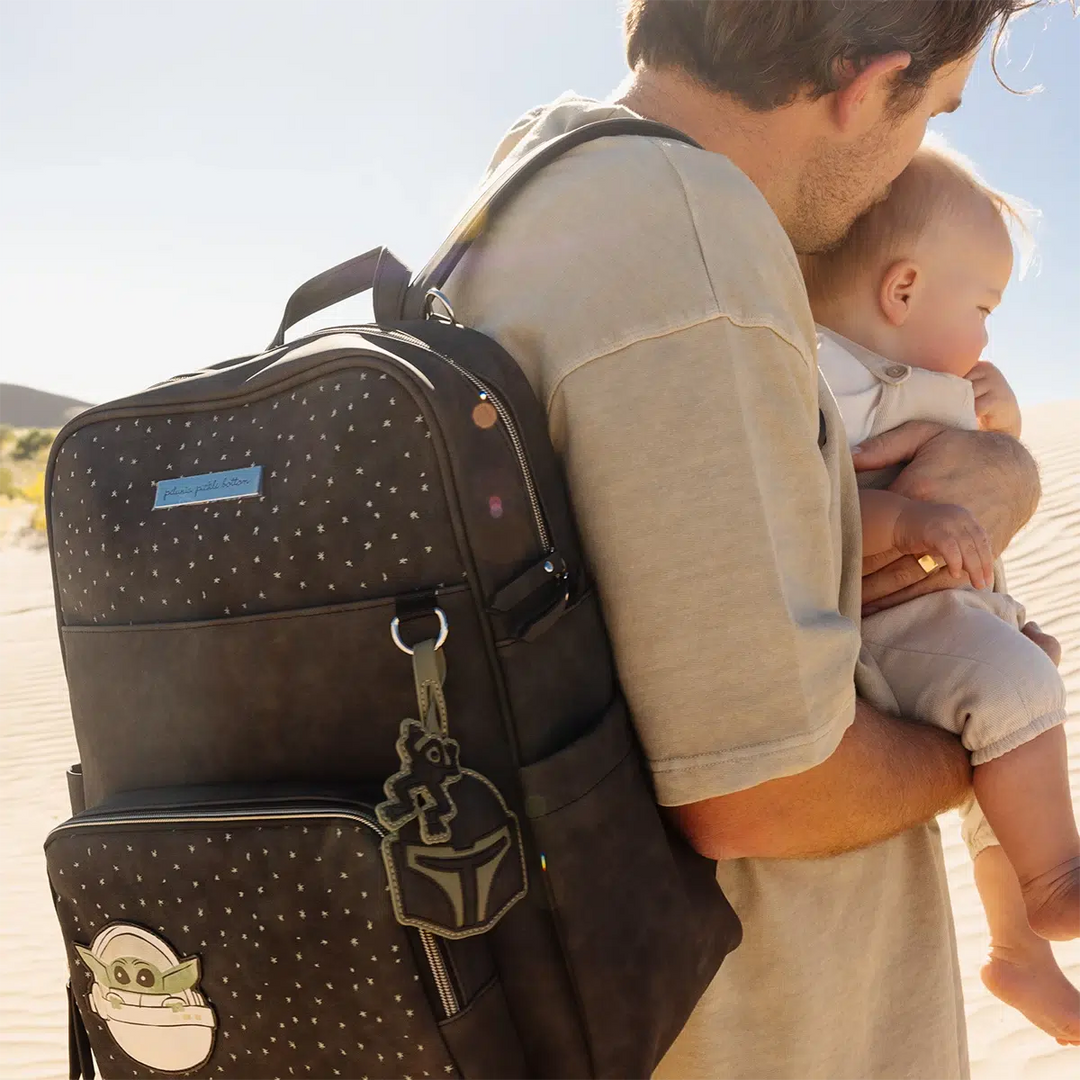 dad wearing the Sync Backpack in The Child while holding baby in arms