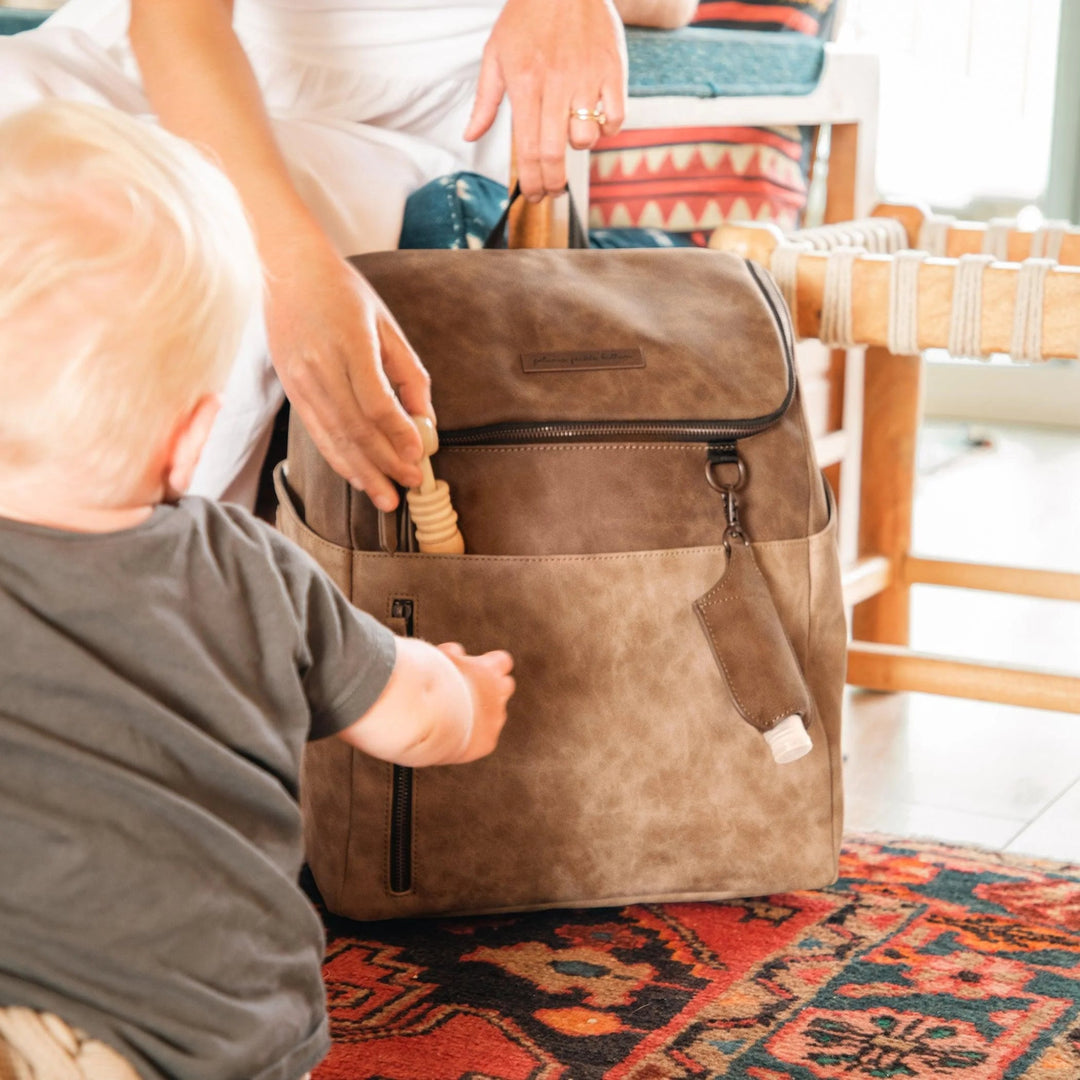 mom putting toy inside the tempo backpack in brioche