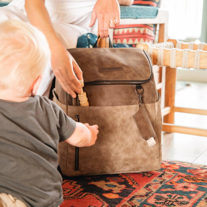 mom putting toy inside the tempo backpack in brioche